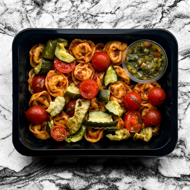 Tortellini au pesto rouge, mozzarella, tomates séchées, roquette et parmesan